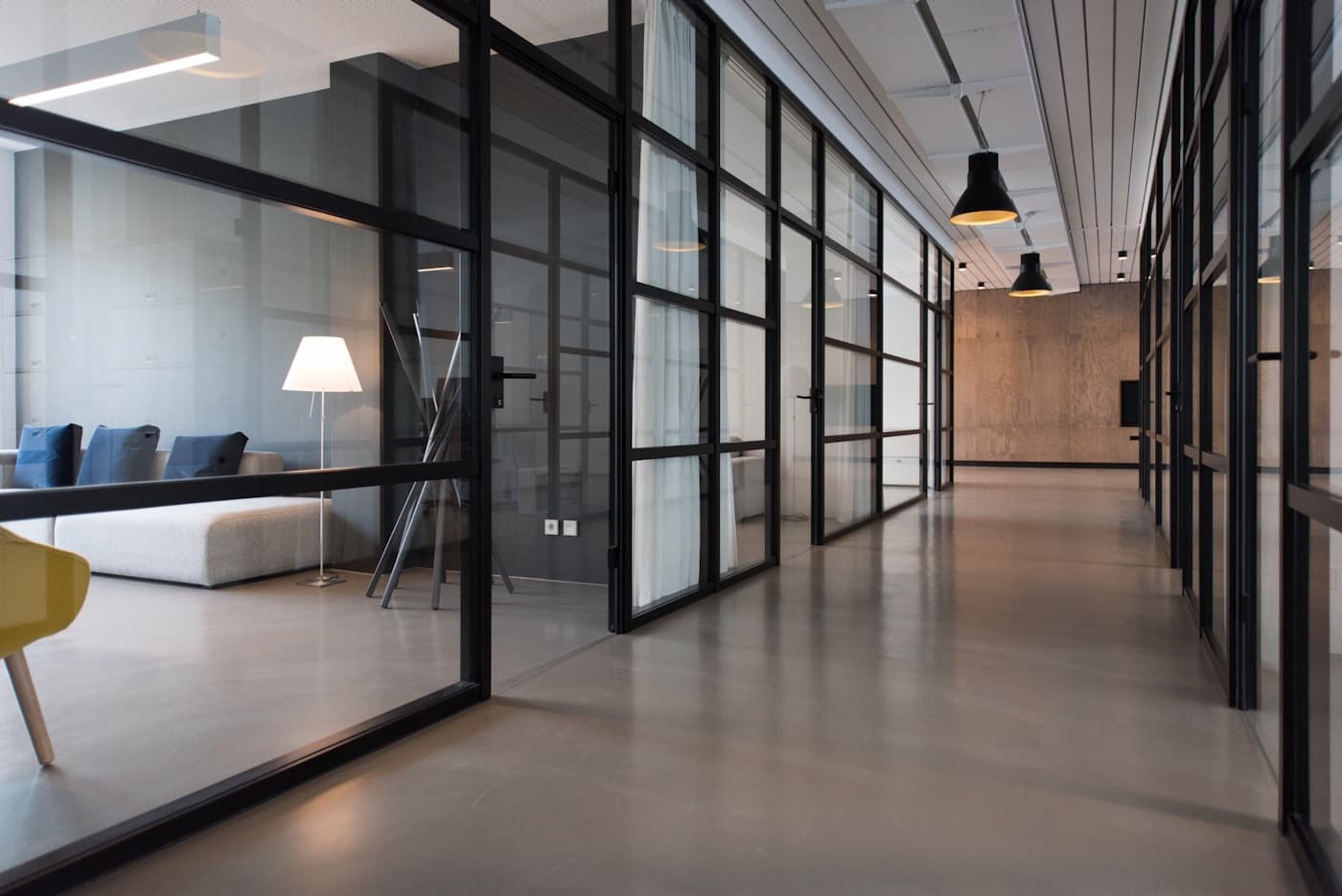 A sunlit professional workspace with glass-walled offices